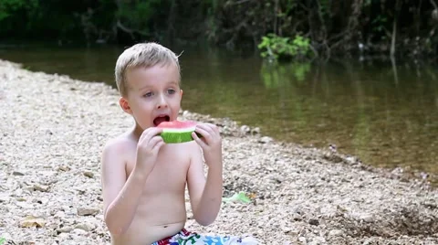 Boy Taking Large Bites of Watermelon At The Creek 스톡 동영상 50445352