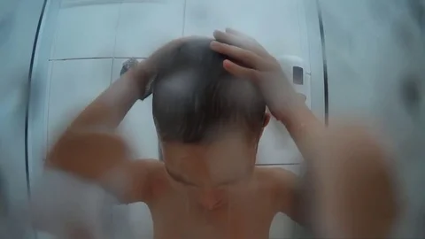 Boy taking a shower under running water. Stock Footage 83992045