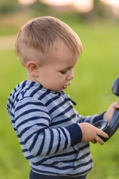 Boy talking on an old phone while standing in the middle of the street Foto stock
