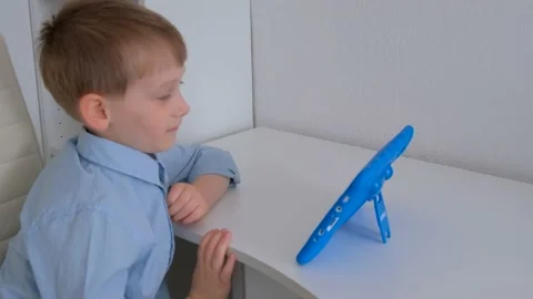 Boy talking via tablet and waving hand Stock Footage 153494531