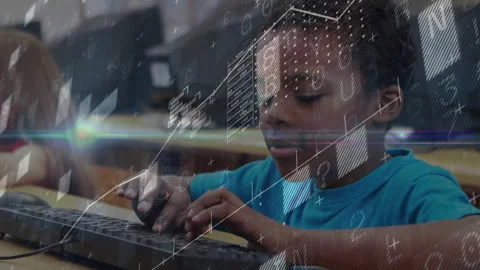 Boy tapping keyboard and animating data overlays on screen in school lab showing 動画素材 316186131