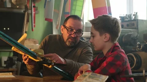A boy with a teacher is studying the device of a mini-airplane engine Vidéo 171011782