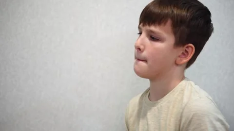 Boy ten years old pumping biceps using two green dumbbells standing in room. clo Stock-Footage 307488999