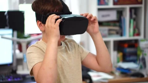 Boy ten years old using virtual reality helmet standing in his room. close up Stock Footage 307490705