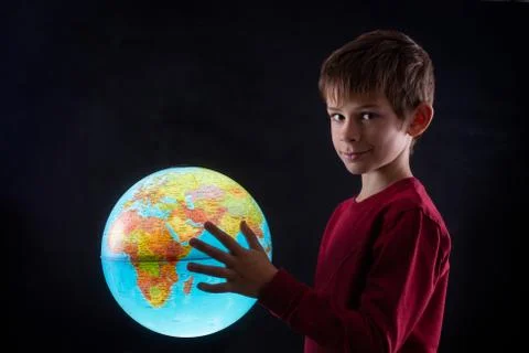 Boy with a terrestrial globe looking at camera Stock Photos