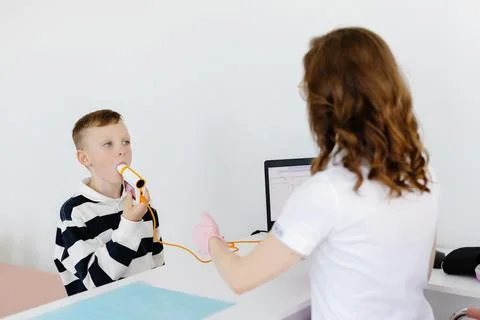 Boy testing breathing function by spirometry in doctors office. Diagnosis o.. Stock Photos