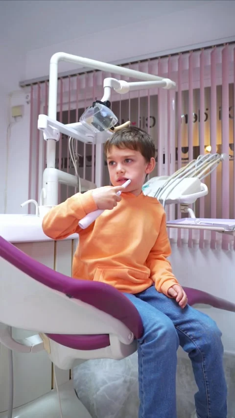 Boy testing an electric toothbrush in a dental clinic office Stock Footage 265757412
