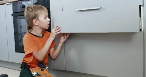 Boy tests drawer operation pulling and pushing after repair Stock Footage 323970879