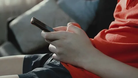 Boy Is Texting on His Phone. The Boy Types a Message on his Smartphone Stock Footage 153319812