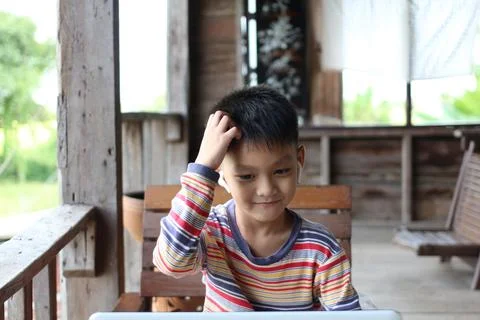 Boy Thinking While Using Laptop in Wooden Cabin Stock Photos