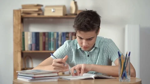 Boy thinks and does the homework Stock Footage 72126478