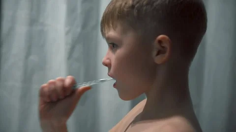 The boy thoroughly brushes his teeth in the bathroom 動画素材 85117236