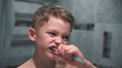 The boy thoroughly brushes his teeth in the bathroom 動画素材 85118598