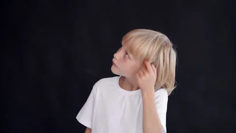 Boy thoughtfully wraps a lock of his hair around his finger Stock Footage 145190708