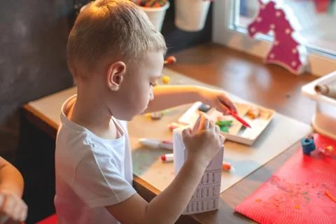 Boy of three years sit at the table and sculpt. Stock Photos