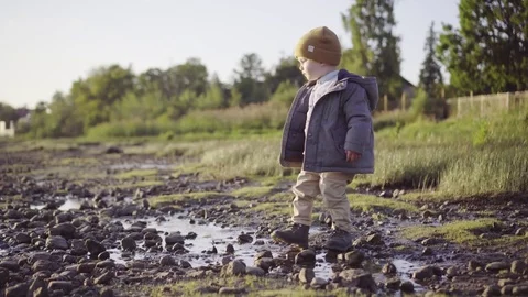 Boy Throwing A Stone Into the puddle Video stock 85373392