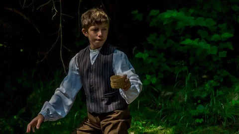 Boy is throwing a tiny wooden basket into the river 스톡 동영상 116961251