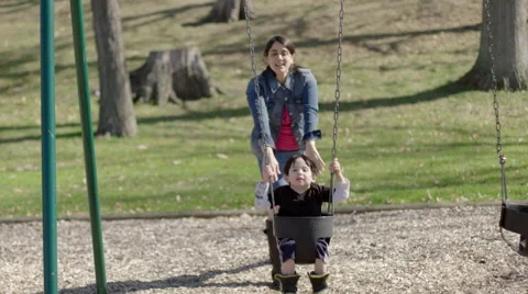 Boy throws head back in delight as he swings 4K Stock Footage 49661476