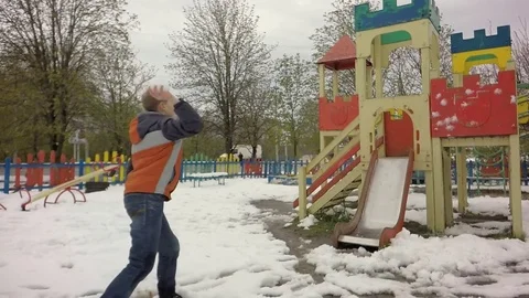 The boy throws snow on the playground. Slow motion. Video stock 74870236