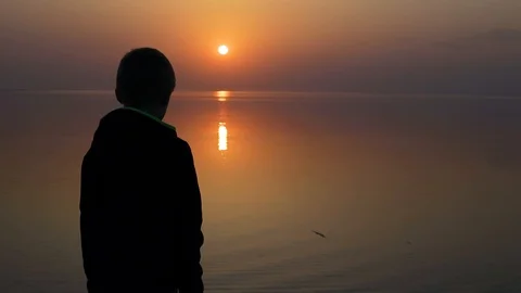 Boy throws a stone into the water Stock Footage 127437580