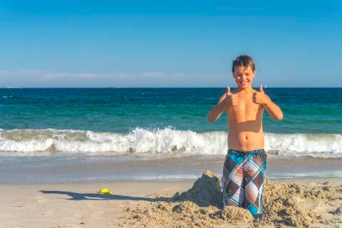 Boy with thumbs up at beach Stock Photos