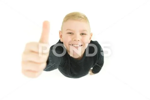The boy thumbs up to the camera. View from above Stock Photos