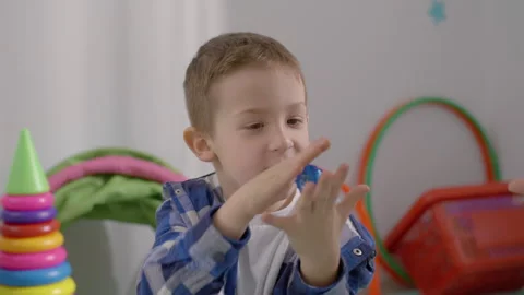 The boy, together with the teacher, performs developmental games in classroom Stock Footage 244536453
