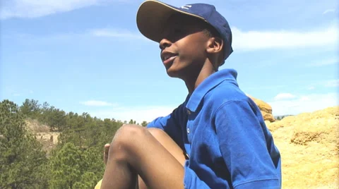 Boy on top of a mountain giving explanation. Stock Footage 27737579