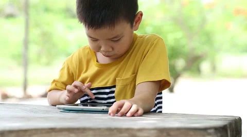 Boy touch on ipad tablet and playing game Stock Footage 51419591