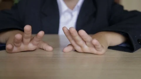 The boy touches his fingers while sitting at his desk Vidéo 78157005