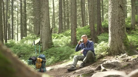 Boy tourist drinks tea at a rest stop in the forest. During the hike Stock Footage 213017355