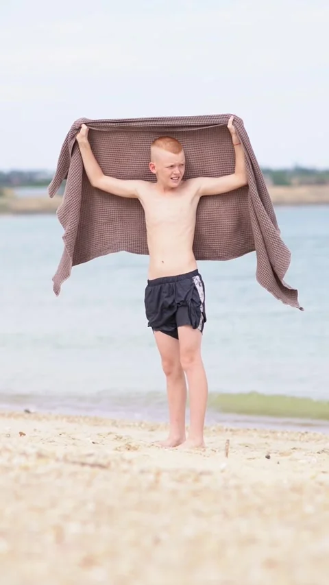 Boy with a towel on the seashore or ocean Stock Footage 314951158