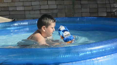 Boy with the toy ship in the pool Stock Footage 26401992