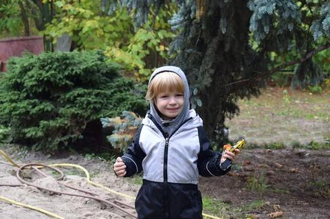 Boy with toys posing in the backyard. Stock Photos
