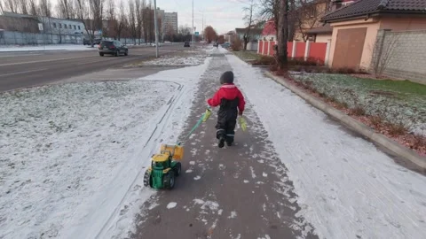 A Boy With A Tractor Is Walking Slow Motion Stock Footage 168984617