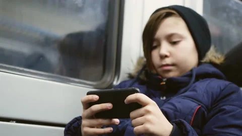 The boy in the train prints messages in the smartphone Stock Footage 104208658