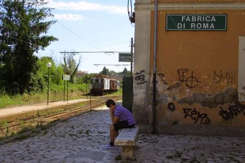 Boy on the train station bench Stock Photos