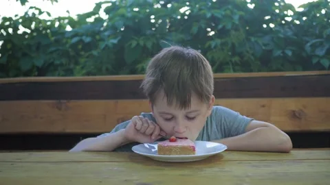 The boy tries the cake, enjoying the process. positive emotions Stock Footage 169296780
