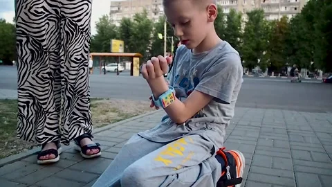 Boy trying to put on his wristwatch Stock Footage 201837311