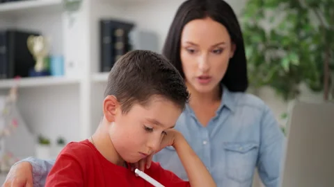 Boy trying to solve difficult math problem with private tutor, homeschooling Stock Footage 230920612