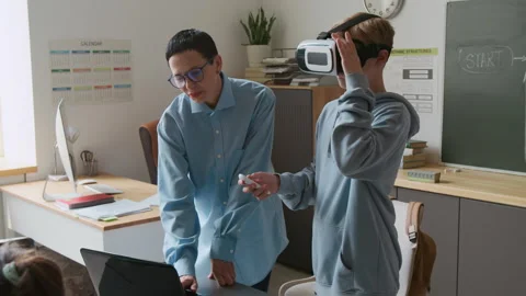 Boy Trying VR Glasses, Teacher Guiding him During IT Class in School Stock Footage 317635981