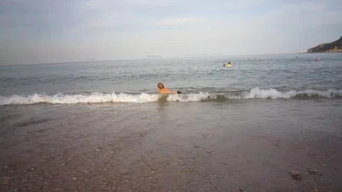 A boy tumbles on the waves in the ocean. Homemade vintage video Stock Footage 238665361