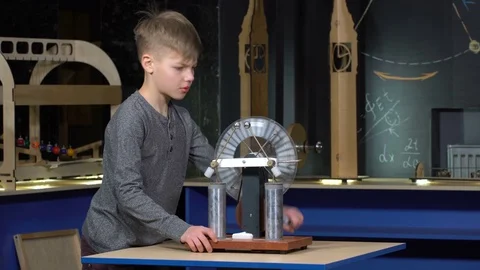 The boy turns the electrostatic machine Stock Footage 72771762