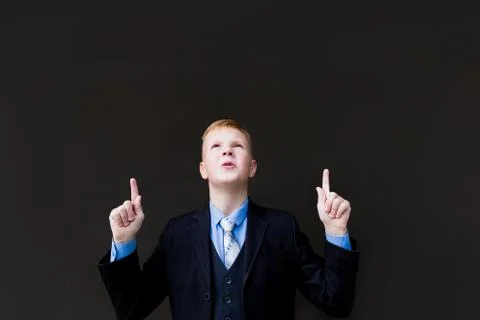 Boy in tuxedo points to the side Stock Photos