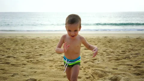 Boy of two years playing on the beach near the ocean. Stock Footage 88431510