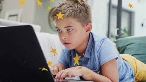 Boy typing laptop, sparking yellow stars crossing face and laptop as camera Stock Footage 333975751