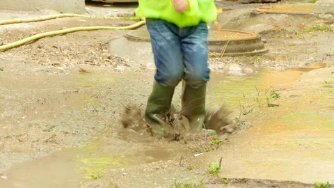 Boy with an umbrella jumping in a puddle Video stock 84330631