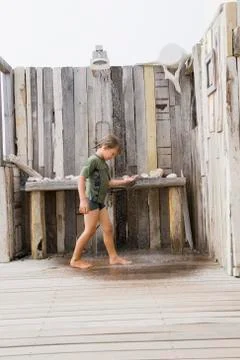 Boy under a beach shower Stock Photos