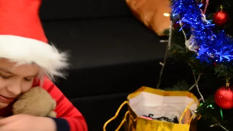 Boy under Christmas tree at home Xmas  drink hot chocolate Kids open presents 動画素材 166552774