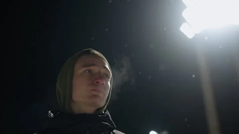 Boy Under Stadium Light with Breath Visible in Cold Air and Falling Snow Stock-Footage 316453711